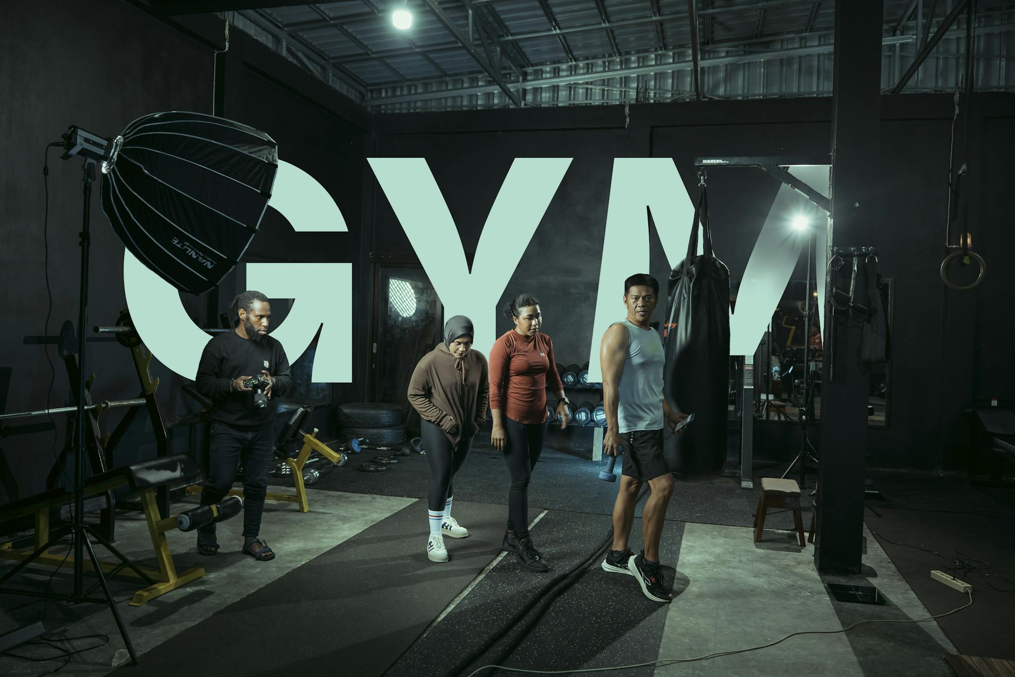 Four people in a gym setting engaged with fitness equipment, showcasing modern athleticism.